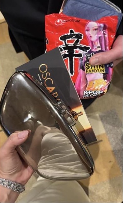 HUNTR/X-edition Shin Ramyun pack held next to an Oscars program